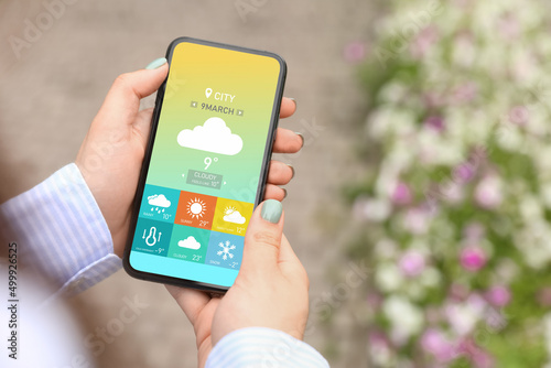 Young woman using weather f...