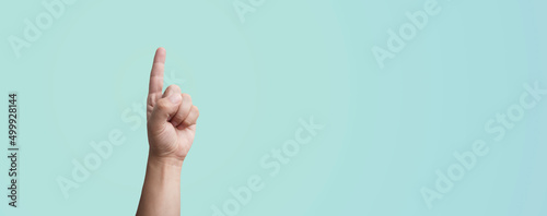 hand pointing finger on a blue background - idea concept or pointing at something photo