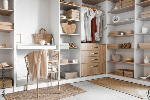 Interior of modern wardrobe with shelves and workplace photo