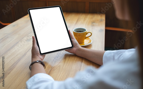 Mockup image of a woman holding digital tablet with blank white desktop screen