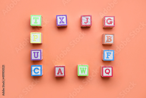 Frame made of wooden cubes with letters on red background