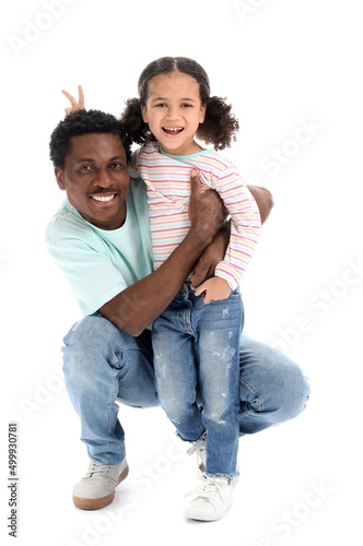 Portrait of happy African-American man and his little daughter on white background