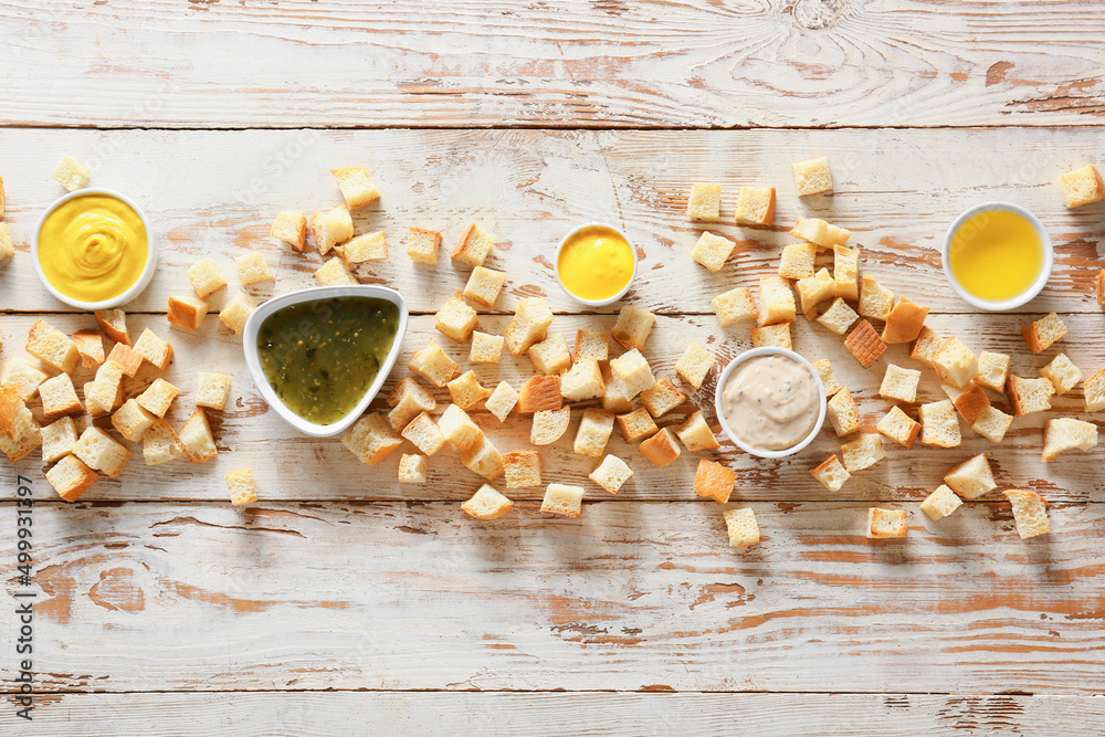 Tasty croutons with sauces on light wooden background Tasty croutons with sauces on light wooden background
