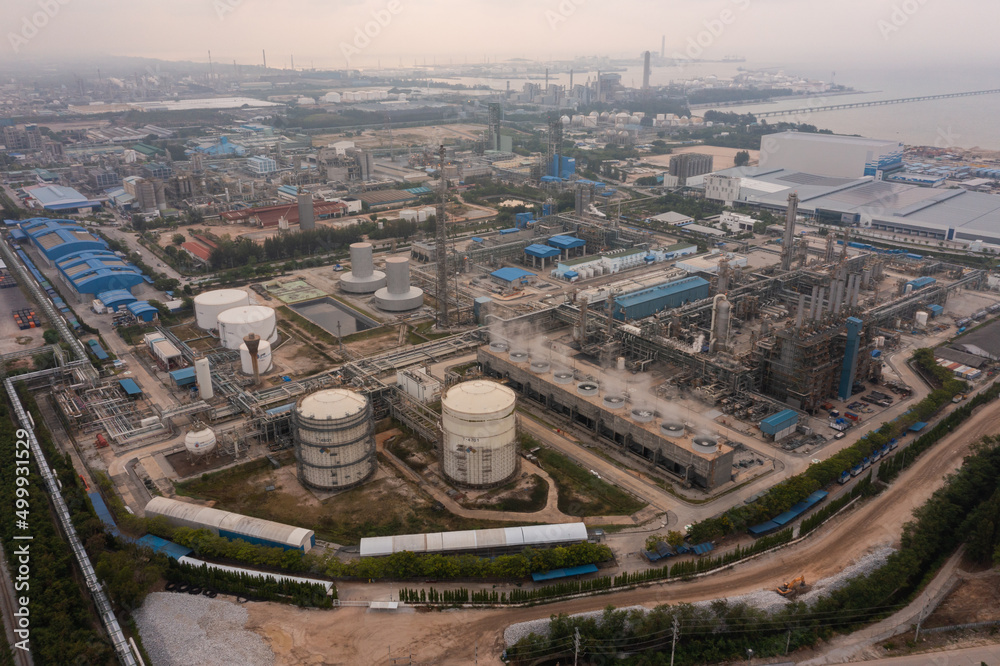 Fototapeta premium Aerial view of petrochemical oil refinery and sea in industrial engineering concept in Bangna district at night, Bangkok City, Thailand. Oil and gas tanks pipelines in industry