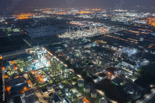 Aerial view of petrochemical oil refinery and sea in industrial engineering concept in Bangna district at night, Bangkok City, Thailand. Oil and gas tanks pipelines in industry