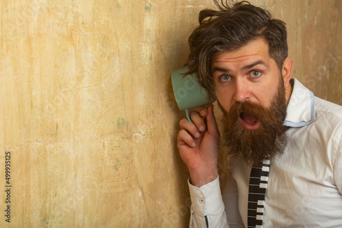 Tableau sur toile Man listening through the wall with the cup