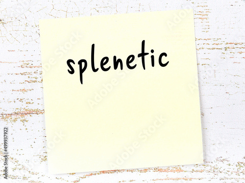 Yellow sticky note on wooden wall with handwritten word splenetic photo