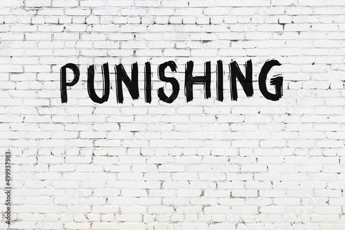 White wall with black paint inscription punishing on it