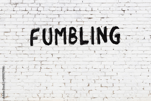 Inscription fumbling painted on white brick wall