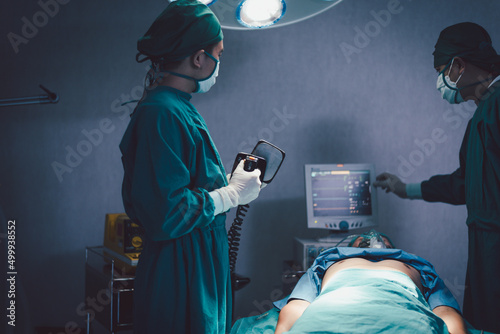 Medical urgency doctor using defibrillator during surgical operation a patient in hospital operating room photo