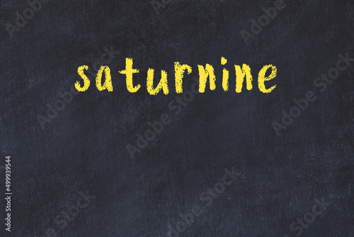 College chalk desk with the word saturnine written on in