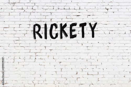 Inscription rickety painted on white brick wall