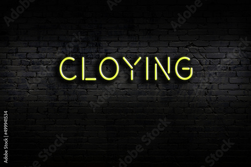 Bild auf Leinwand Neon sign. Word cloying against brick wall. Night view