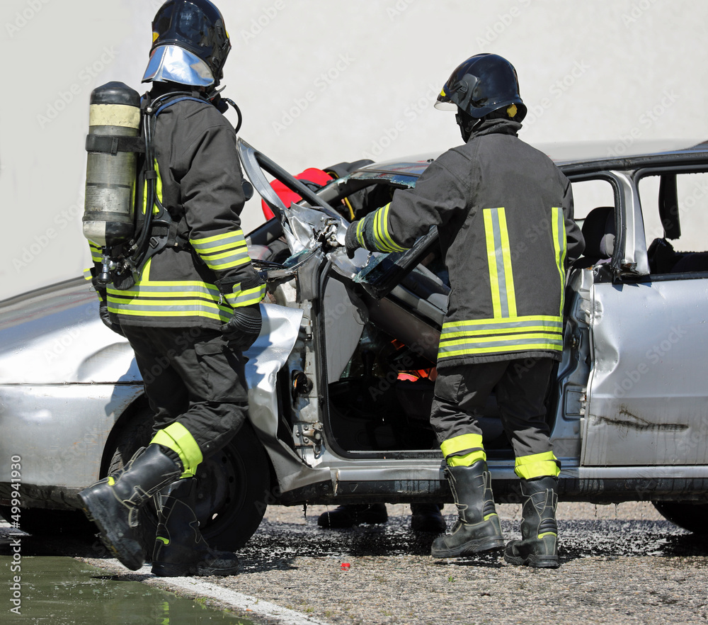firefighters with oxygen cylinder during the rescue intervention of the person seriously injured due to the road accident firefighters with oxygen cylinder during the rescue intervention of the person seriously injured due to the road accident