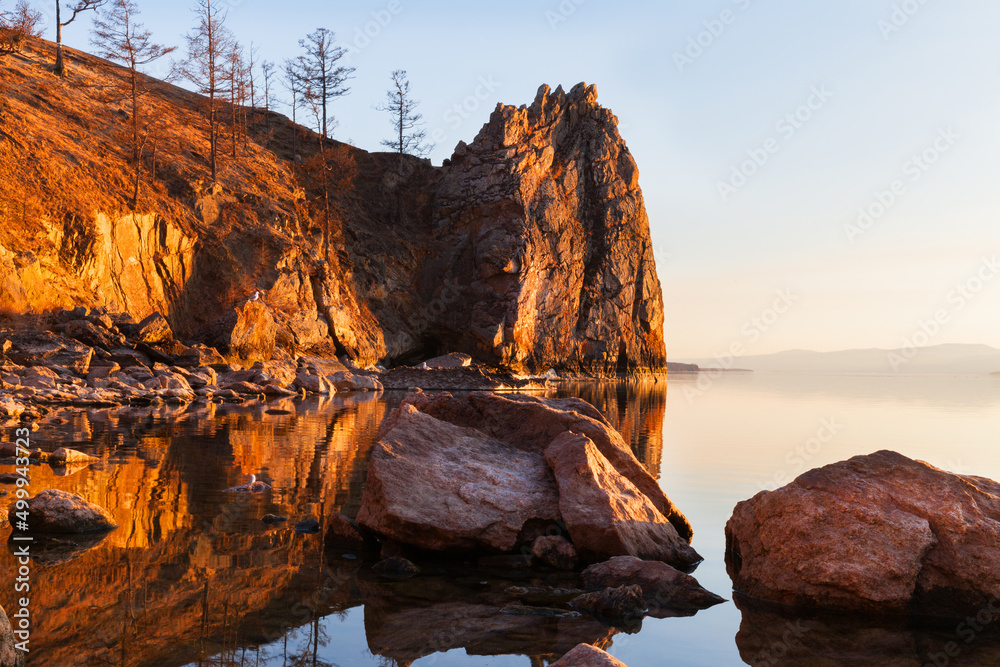 Baikal Lake on May evening. Beautiful rocks of Olkhon Island near the village of Khuzhir are illuminated by the warm light of the setting sun. Natural background. Spring travel and outdoor recreation
