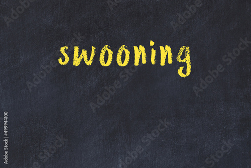 Konstfotografi College chalk desk with the word swooning written on in