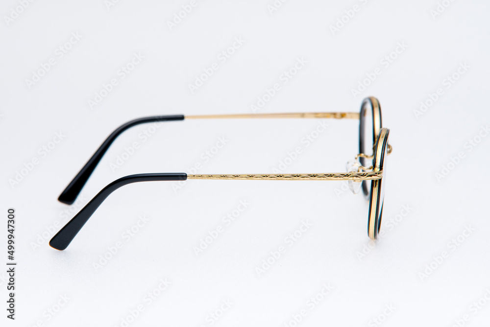 Round shape sunglasses gold and black frames on white background Round shape sunglasses gold and black frames on white background