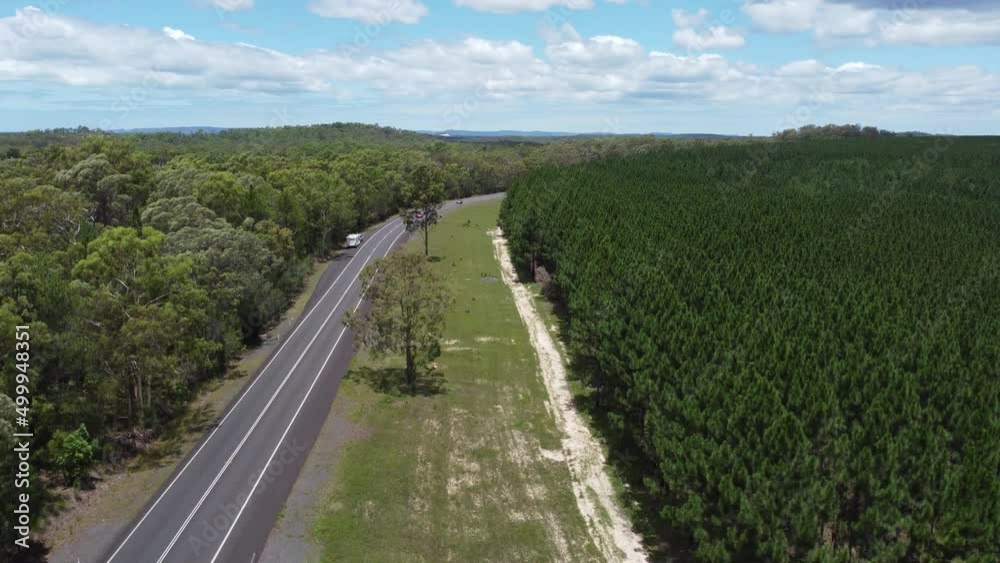 Drone ascending over a highway and forest