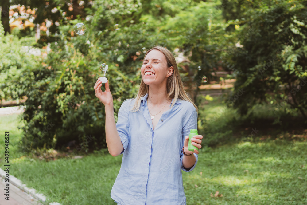 young woman blowing bubbles in the park and having fun young woman blowing bubbles in the park and having fun