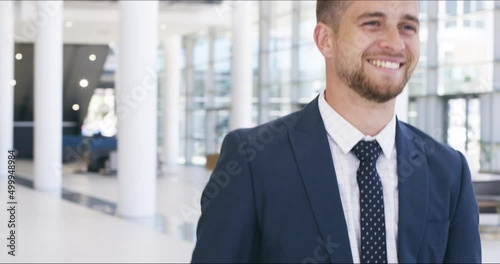 Handsome young business man making rock on signs while walking through the office. Happy business man with a carefree attitude at work
