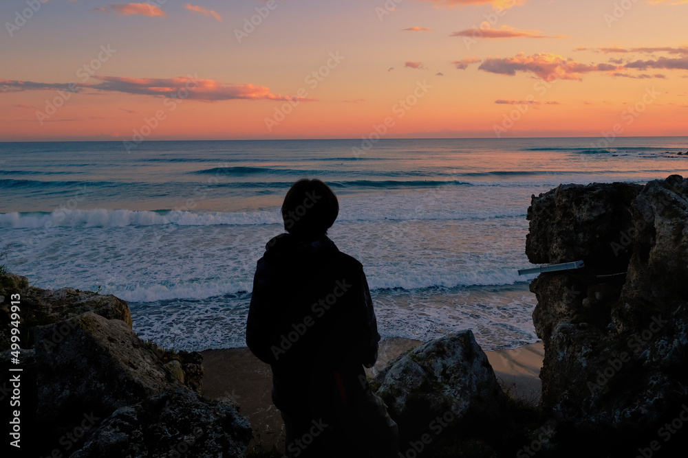 silhouette of a person on the beach at sunset