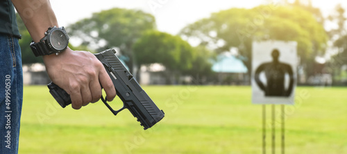 9mm automatic pistol holding in right hand of shooter, concept for security, robbery, gangster, bodyguard around the world. selective focus on pistol.