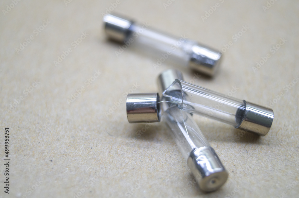 Broken electrical fuses with split glass housing. Broken glass tube