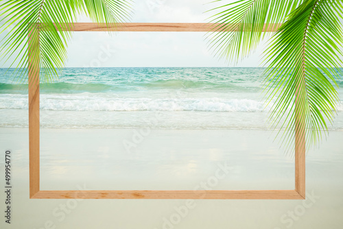 Fototapeta Naklejka Na Ścianę i Meble -  Blank board mockup frame on sand beach at coast with blur blue sea bokeh and blue sky on day background. card or poster for tourism relax vacation tropical travel nature ocean. summer holidays concept