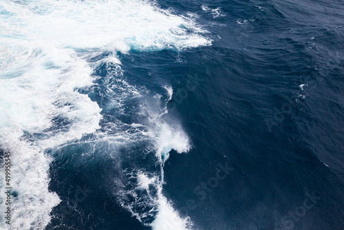 Ocean close up. Background of blue water with white foam.