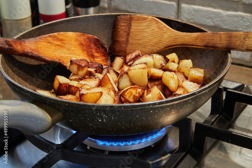 Frying pan with fried potatoes on gas stove. Step by step recipe