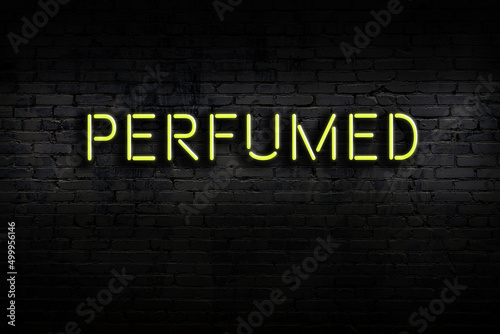 Night view of neon sign on brick wall with inscription perfumed