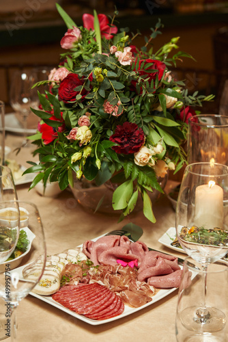 meat cuts on a festive table decorated with red flowers