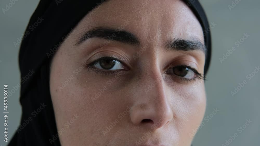 Close-up of a modest Arab woman. This woman does not use makeup. A woman has natural beauty. Muslim rules for women who profess Islam and wear a black hijab. Islamic world in the Middle East. Close-up of a modest Arab woman. This woman does not use makeup. A woman has natural beauty. Muslim rules for women who profess Islam and wear a black hijab. Islamic world in the Middle East.