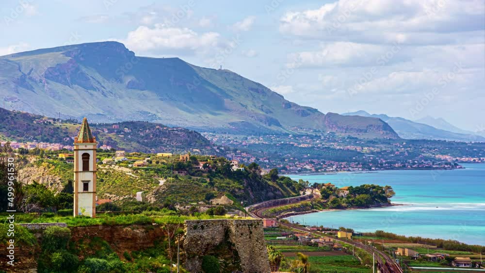 Time lapse shot of rural coastline of Sicily and church during sunny day - Beautiful mountain range in background - View from Belvedere Termini Imerese,Italy