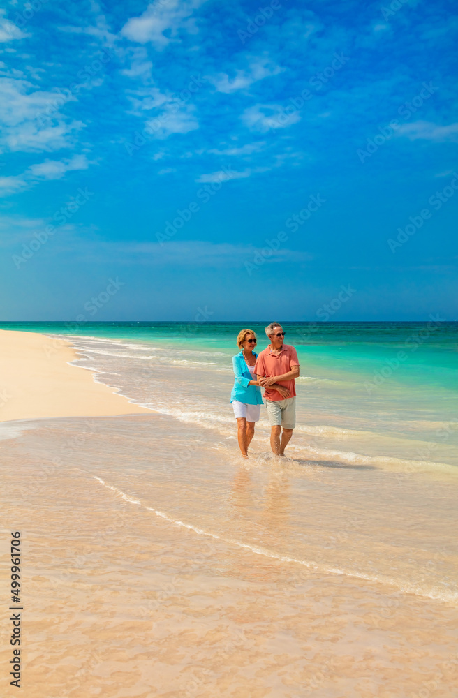 Retired couple in casual clothing walking on beach Retired couple in casual clothing walking on beach