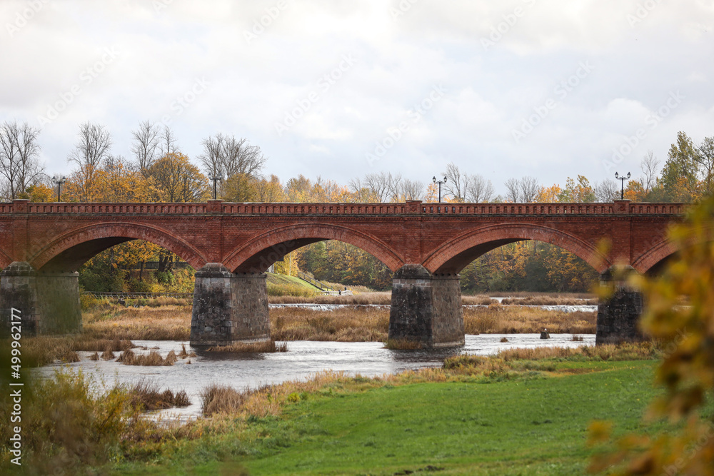 Autumn weather view of old red brick over Venta river in small countryside city Kuldiga, Latvia. Autumn weather view of old red brick over Venta river in small countryside city Kuldiga, Latvia.