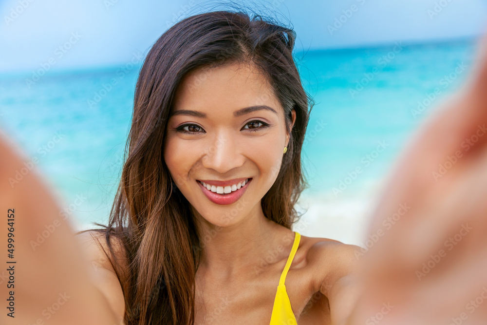 Smiling Asian female taking selfie by tropical ocean Smiling Asian female taking selfie by tropical ocean
