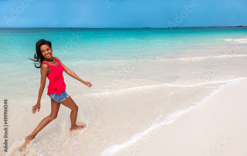 Happy African American girl playing in ocean Bahamas