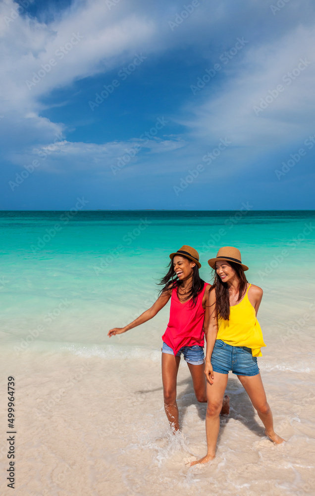 Friends wearing Panama hats standing in tropical ocean Friends wearing Panama hats standing in tropical ocean