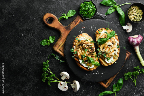 Vegan Sandwich with mushrooms, cheese and basil. Bruschetta. Top view. On a stone background.