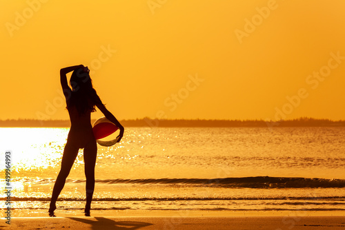 Silhouette of Asian woman on shoreline at sunrise