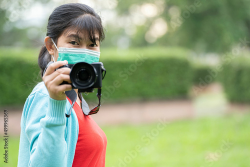 Woman is a professional photographer with  camera, outdoor and sunlight, Portrait, copy space.Beautiful woman taking picture outdoors © nuttapon