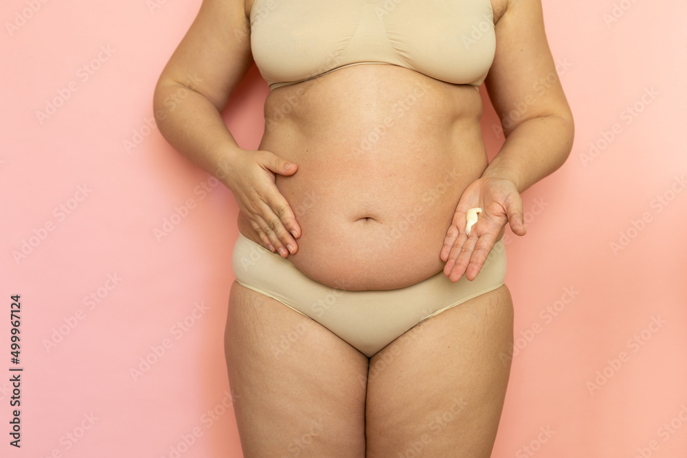 Premium Photo  Cropped overweight woman in underwear applying moisturizer  cream lotion to her abdomen postnatal period skin recovery