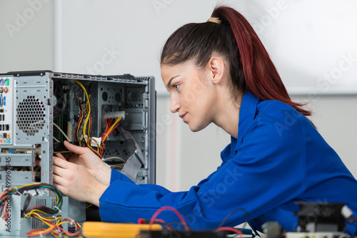 female technician repairing dismantled computer photo