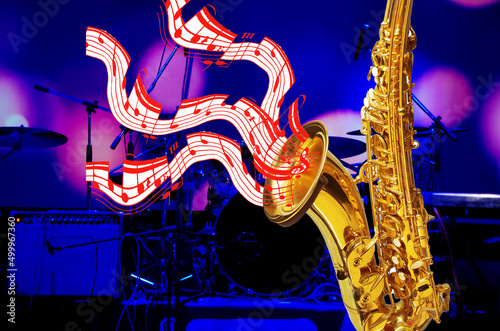 A golden saxophone from which musical notes fly out against the background of a stage. photo