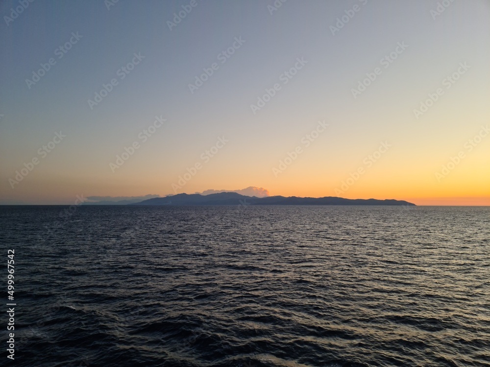 Panorama of the island from the sea after sunset over the horizon
