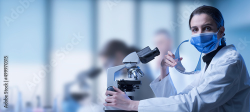 Researcher using a microscope in the lab photo