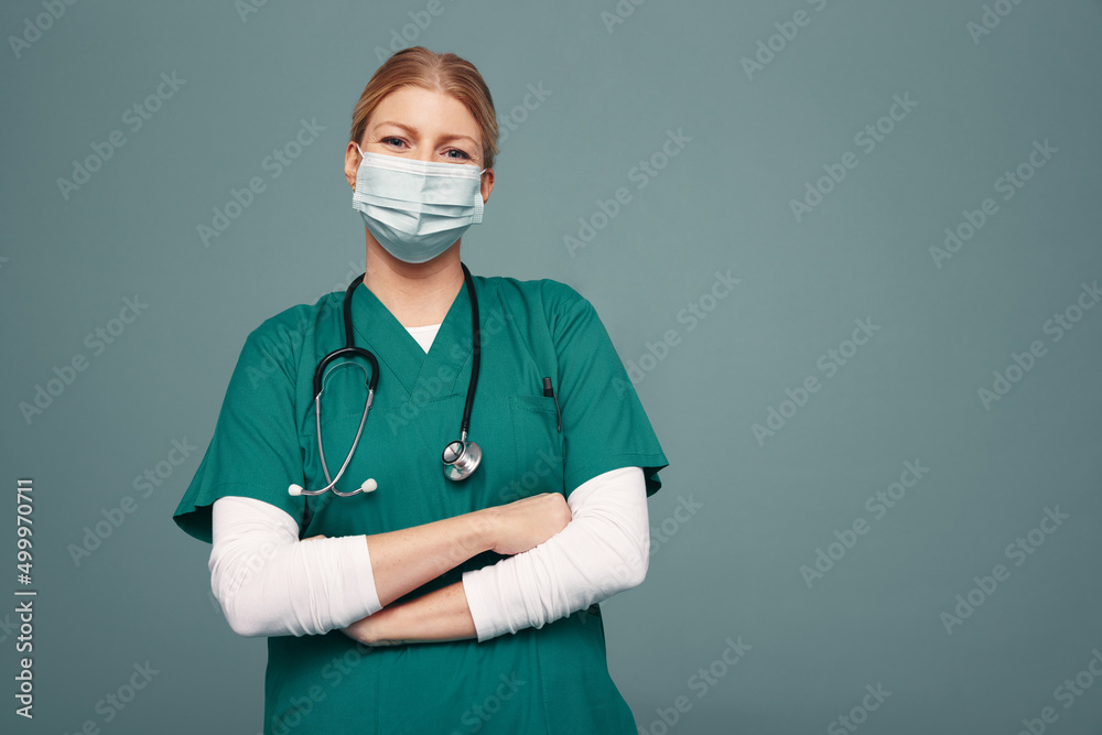Female doctor wearing a face mask and green scrubs