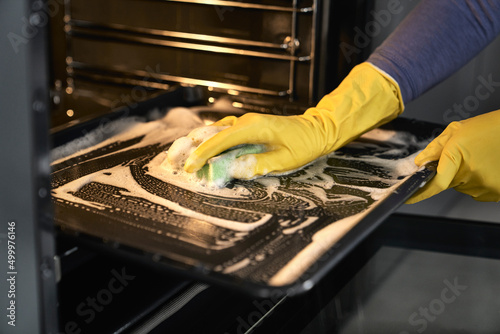 Close up of caucasian woman cleaning oven at home