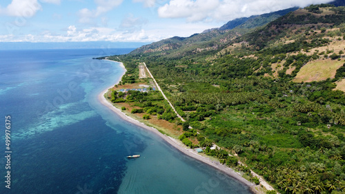 The aeroplane small landing strip, lush green landscape during wet season and perfect turquoise ocean with coral reefs on Atauro Island, Timor Leste photo